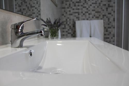 a bathroom sink with a faucet and a vase at Quinta do Miradouro in Portalegre