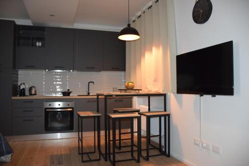 a kitchen with black cabinets and bar stools at Casa Fornace in Ala