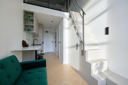 a kitchen and a living room with a green couch at 21 Stylish Lofts by Dream Stay in Tallinn
