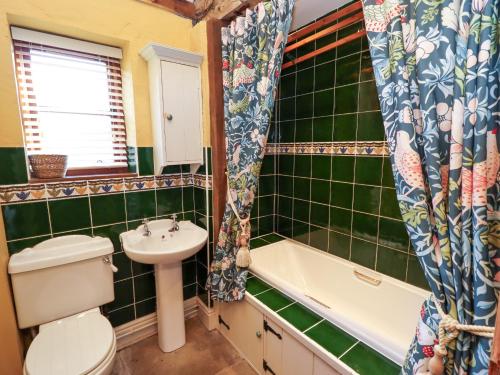 a bathroom with a toilet and a sink and a bath tub at The Old Dairy in Shrewsbury