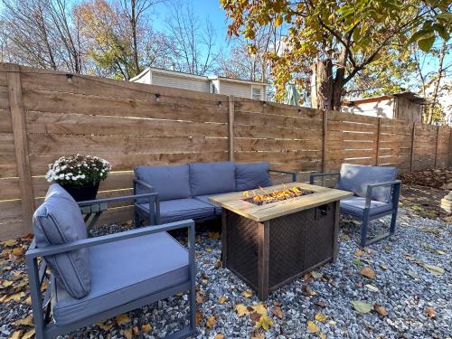 a patio with a couch and two chairs and a table at Designer Home, Hot Tub, Private Yard, & Projector in Hudson