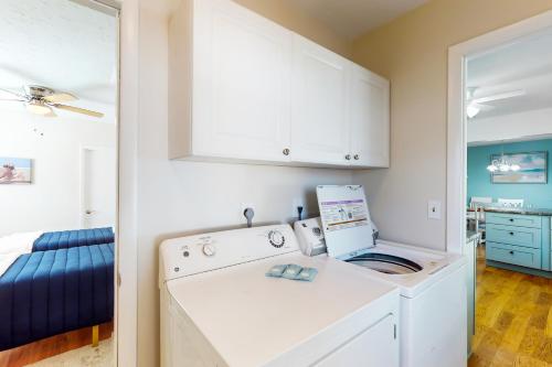 eine Waschmaschine und einen Trockner in einem Zimmer mit einem Schlafzimmer in der Unterkunft Coastal Cottage in Bradenton