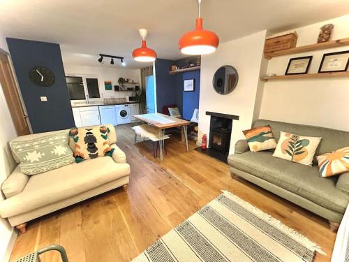 a living room with two couches and a table at Bungalow, mountain and sea views parking in Aberdyfi