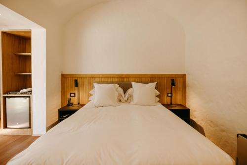 a bedroom with a large white bed with two night stands at La Posada del Puente in Arequipa