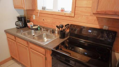 a kitchen with a sink and a stove at The Cave at Shady Woods - 1 Bedroom Studio - Walk to Downtown! in Gatlinburg