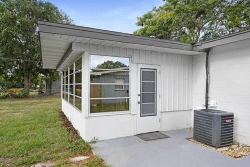 a small white building with a door and a window at Catchy Relax Bradenton Beauty mins to Beaches in Bradenton
