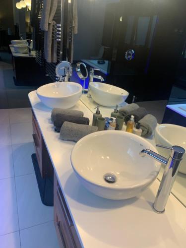 a bathroom with two sinks and two mirrors at Luxury 5-Bedroom Retreat in the Heart of Cheshire in Hale