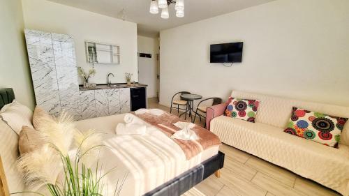 a living room with a bed and a couch at KYD VILA - Studiouri si Apartamente la 100m de Plaja Debarcader in Eforie Nord