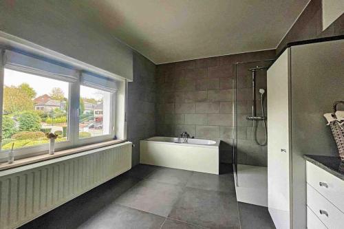 La salle de bains est pourvue d'une baignoire, d'un lavabo et d'une fenêtre. dans l'établissement Charleville 39 I Bruxelles-charleroi-aéroport, à Charleroi