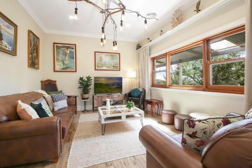un soggiorno con un divano e un tavolo di Orchard House a Beechworth