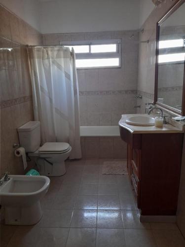 a bathroom with a toilet and a sink and a tub at Casa Quinta Estilo Campo in Lobos