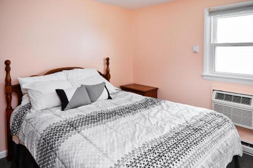 1 dormitorio con 1 cama con edredón blanco y negro en Sand Dollar Villa, en Chincoteague