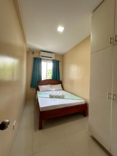 una piccola camera da letto con letto e tende blu di The Cozy Casita a Manila