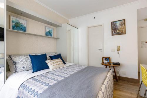 1 dormitorio con 1 cama grande con almohadas azules en Itaim Bibi Club Hoteling, en São Paulo