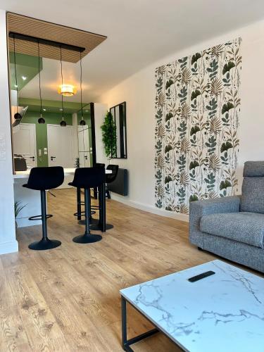 een woonkamer met een bank en een tafel bij Le Chardon- appartement 2chambres- avec stationnement in Nancy
