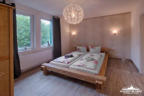 um quarto com uma cama grande e um lustre em Auszeit-im-Harz Haus 2 Wohnung 1 em Schierke
