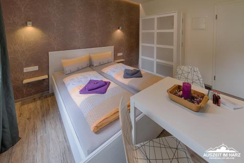 Habitación pequeña con cama, mesa y escritorio. en Auszeit-im-Harz Haus 2 Wohnung 2, en Schierke