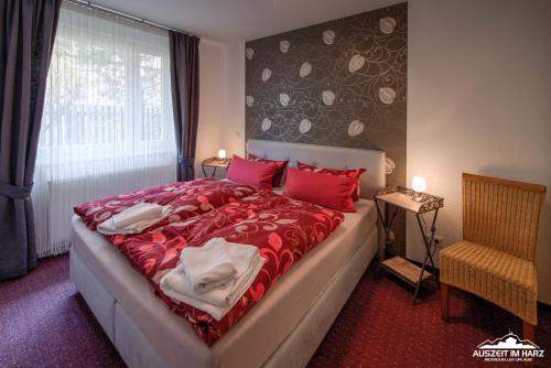 um quarto com uma cama com lençóis vermelhos e uma janela em Auszeit-im-Harz Haus 6 Wohnung 2 em Wernigerode