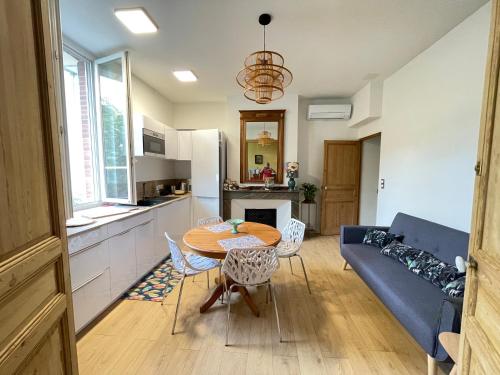un salon avec une table et un canapé bleu dans l'établissement Villa Pierre, à Toulouse