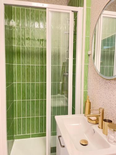une salle de bain verte avec un lavabo et une douche dans l'établissement Villa Pierre, à Toulouse