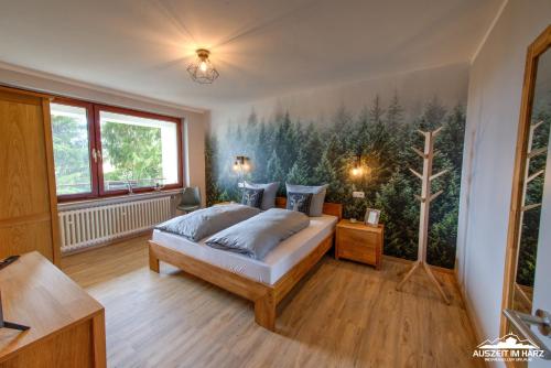 - une chambre avec un lit et une peinture murale dans l'établissement Auszeit-im-Harz Haus 3 Wohnung 4, à Braunlage