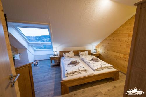 een slaapkamer met een bed en een groot raam bij Auszeit-im-Harz Haus 3 Wohnung 8 in Braunlage