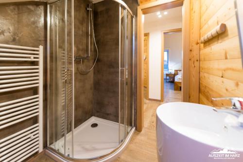 een badkamer met een douche en een wit bad bij Auszeit-im-Harz Haus 3 Wohnung 8 in Braunlage
