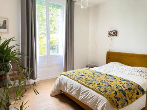 une chambre avec un lit et une grande fenêtre dans l'établissement Villa Pierre, à Toulouse