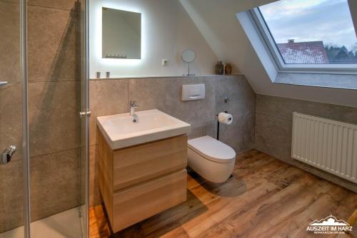 La salle de bains est pourvue d'un lavabo, de toilettes et d'une fenêtre. dans l'établissement Auszeit-im-Harz Haus 5 Wohnung 31, à Stiege