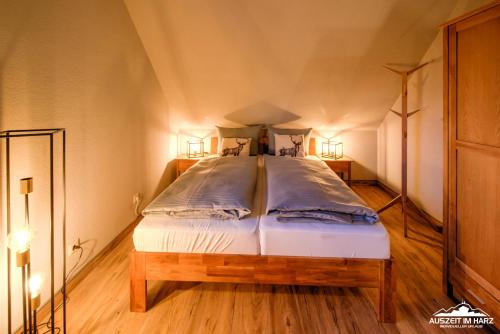 Cette chambre comprend un grand lit et 2 lampes. dans l'établissement Auszeit-im-Harz Haus 5 Wohnung 31, à Stiege
