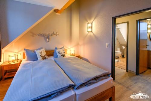 Un dormitorio con una cama grande con almohadas azules. en Auszeit-im-Harz Haus 5 Wohnung 33, en Stiege