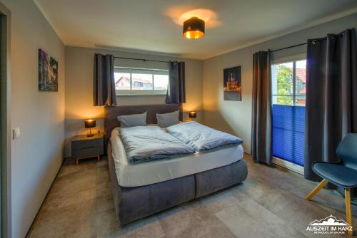 a bedroom with a bed and a desk and a chair at Auszeit-im-Harz Haus 6 Ferienhaus in Wernigerode