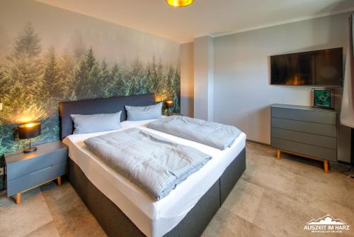 a bedroom with a large bed and a tv at Auszeit-im-Harz Haus 6 Ferienhaus in Wernigerode