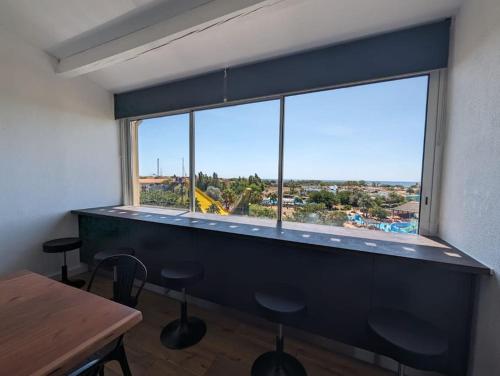 Cette chambre dispose d'une grande fenêtre avec une table et des chaises. dans l'établissement Cap d'Agde - Secteur Richelieu 10 couchages, au Cap d'Agde