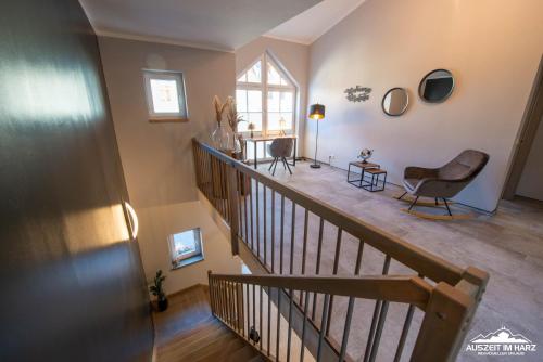 a living room with a staircase and a chair at Auszeit-im-Harz Haus 6 Ferienhaus in Wernigerode