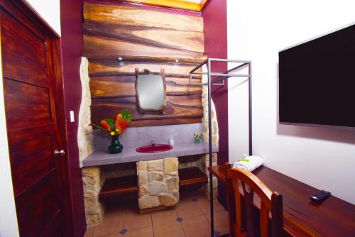W łazience znajduje się umywalka i lustro. w obiekcie HOTEL LA RIVIERA w mieście Sabalito
