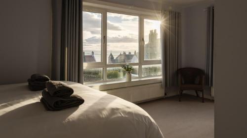 a bedroom with a bed and a large window at Susie's Place in Elie