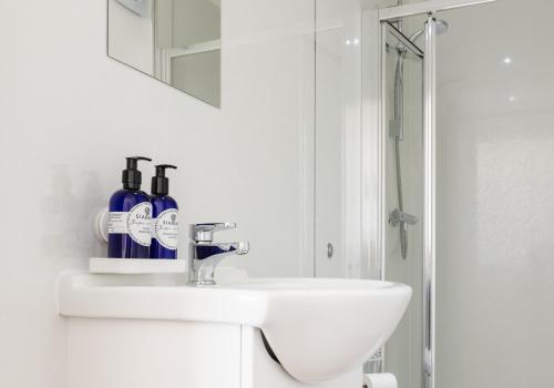 a white bathroom with a sink and a mirror at Susie's Place in Elie