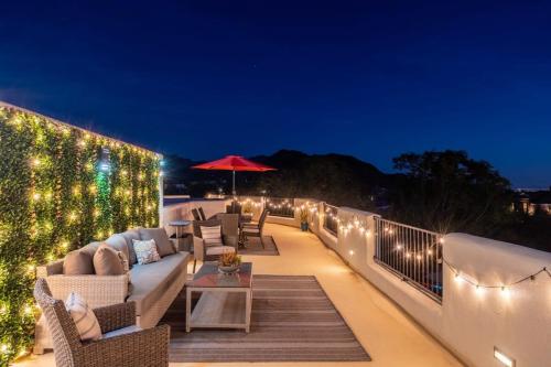 a patio with a couch and chairs on a deck with lights at Golf Sim & Putting Green - Rooftop with 360 Views in Scottsdale