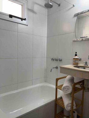 ein weißes Badezimmer mit Badewanne und Waschbecken in der Unterkunft Cálido Apto en el corazón de Tuc in San Miguel de Tucumán