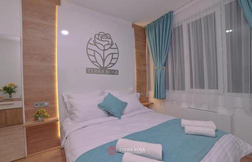 a bedroom with a large bed with towels on it at Хотел Терра Роза in Karlovo