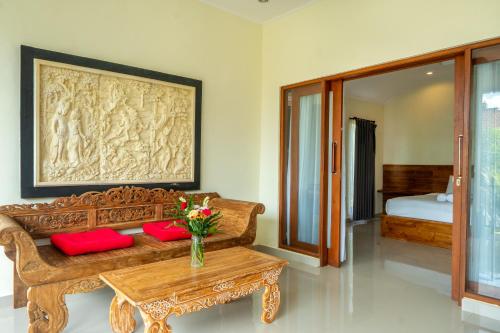 a living room with a couch and a table with red pillows at Pondok Aruna in Ubud