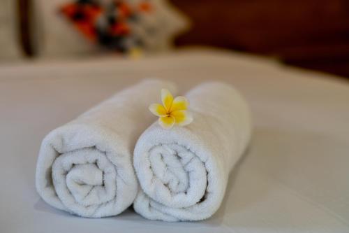 a towel with a flower on top of it at Pondok Aruna in Ubud