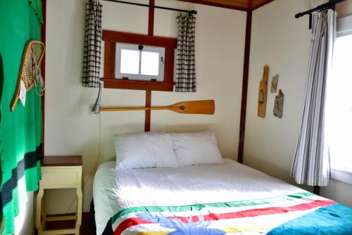 Habitación pequeña con cama y ventana en Banff Beaver Cabins en Banff