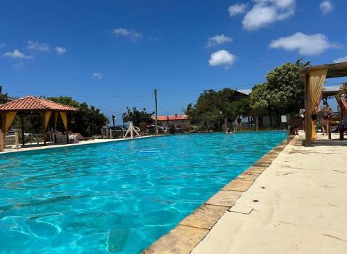 een groot zwembad met blauw water bij Casa Ágata in Cidreira