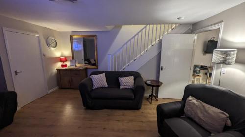 a living room with two chairs and a staircase at 3 bedroom detached by the sea in Prestatyn