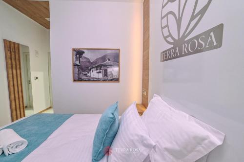 a bedroom with a bed with a sign on the wall at Хотел Терра Роза in Karlovo