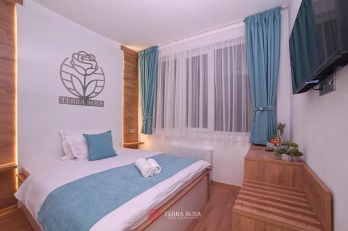 a small bedroom with a bed and a window at Хотел Терра Роза in Karlovo