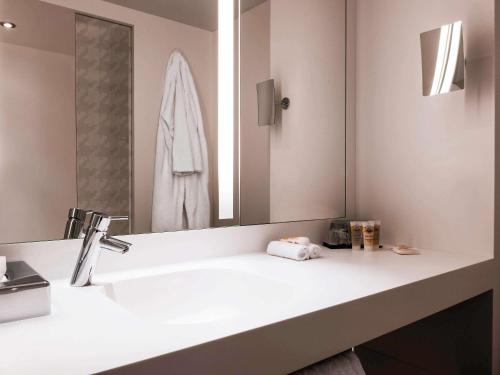 La salle de bains est pourvue d'un lavabo et d'un miroir. dans l'établissement Mercure Paris CDG Airport & Convention, à Roissy-en-France