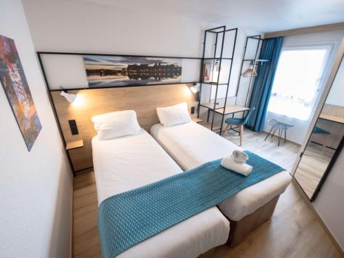 una camera d'albergo con due letti e una coperta blu di ibis Avignon Centre Pont De L'Europe ad Avignone